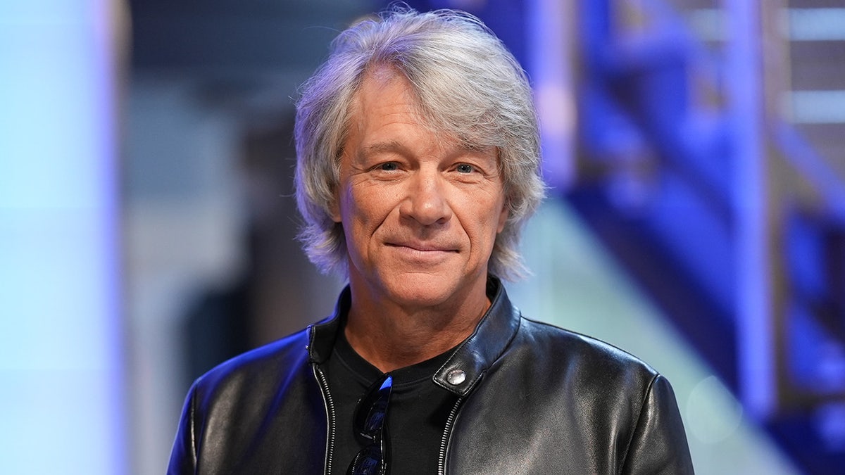 Jon⁢ Bon Jovi⁣ soft smiles and ‍looks directly into⁤ the camera wearing ⁣a leather jacket